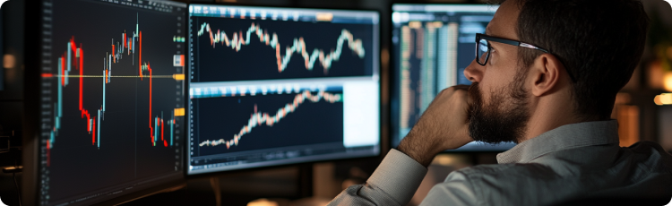 Un hombre de traje examina gráficos del mercado de valores mostrados en una pantalla, centrado en el análisis de datos financieros.