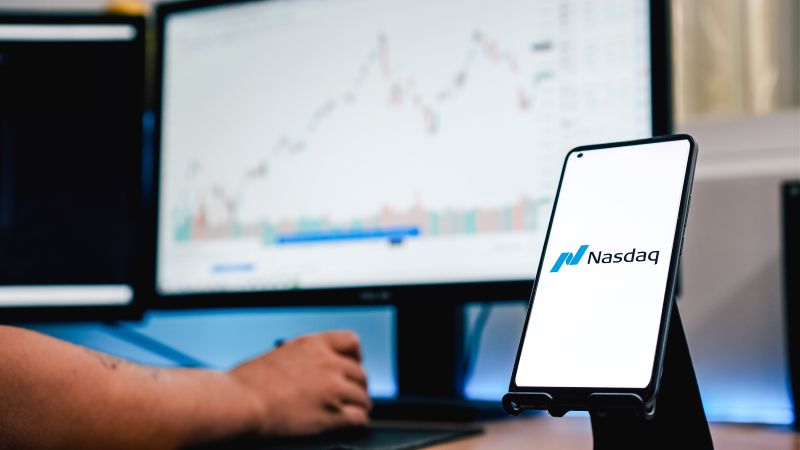 Imagen de una persona frente a un mÃ³vil en el que se lee Nasdaq
