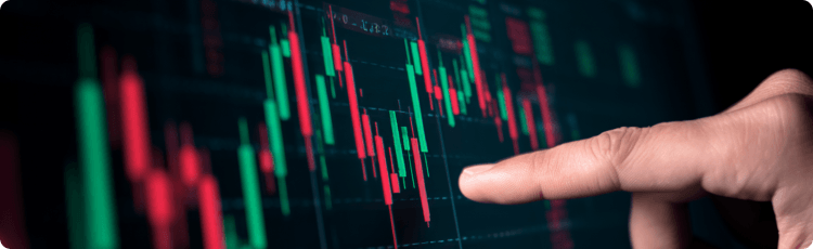 Una mano seÃ±ala un grÃ¡fico digital de velas japonesas que muestra los movimientos del mercado y la evoluciÃ³n de los precios a corto plazo