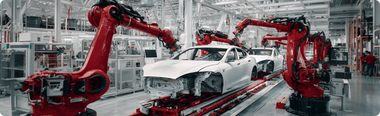 Lini perakitan manufaktur mobil dengan robot industri yang merakit bodi kendaraan berwarna putih.