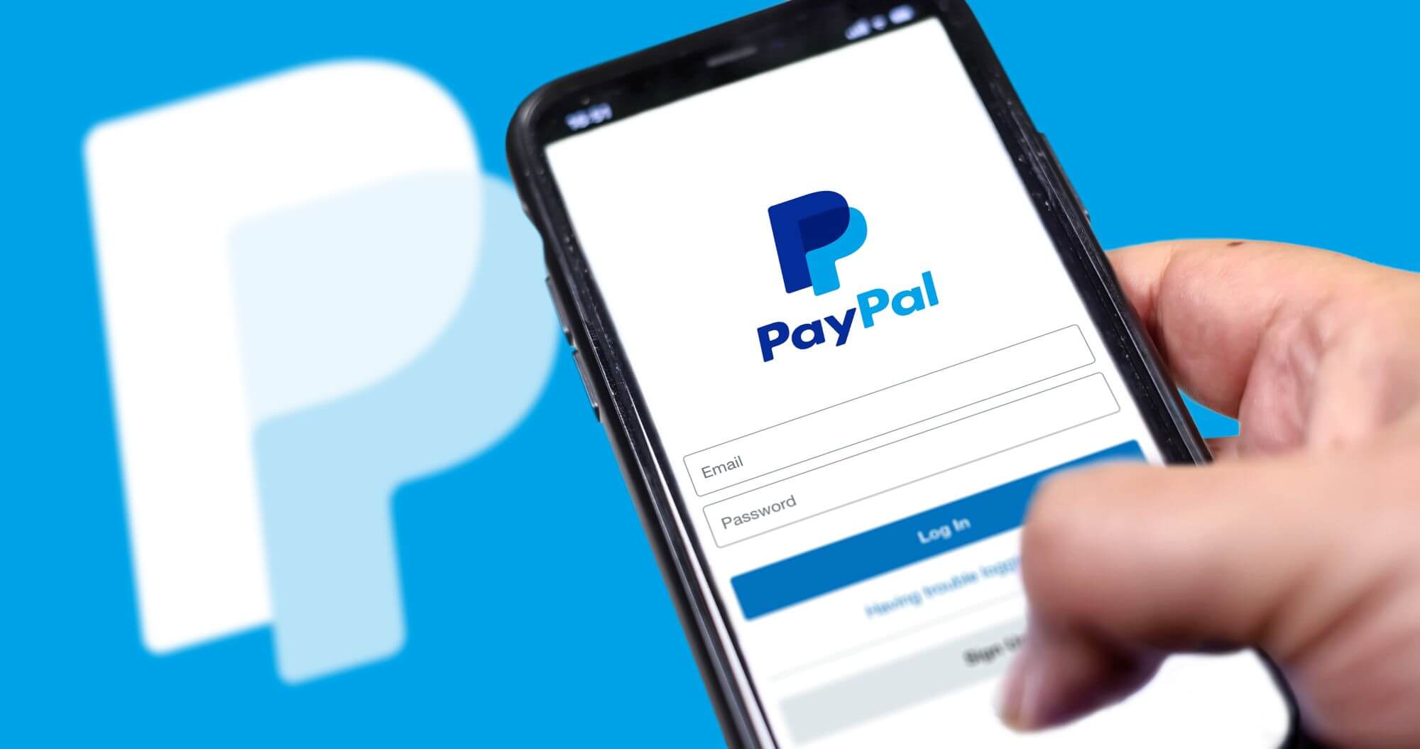 Imagen de una persona sosteniendo un mÃ³vil en el que se ve el logo de PayPal