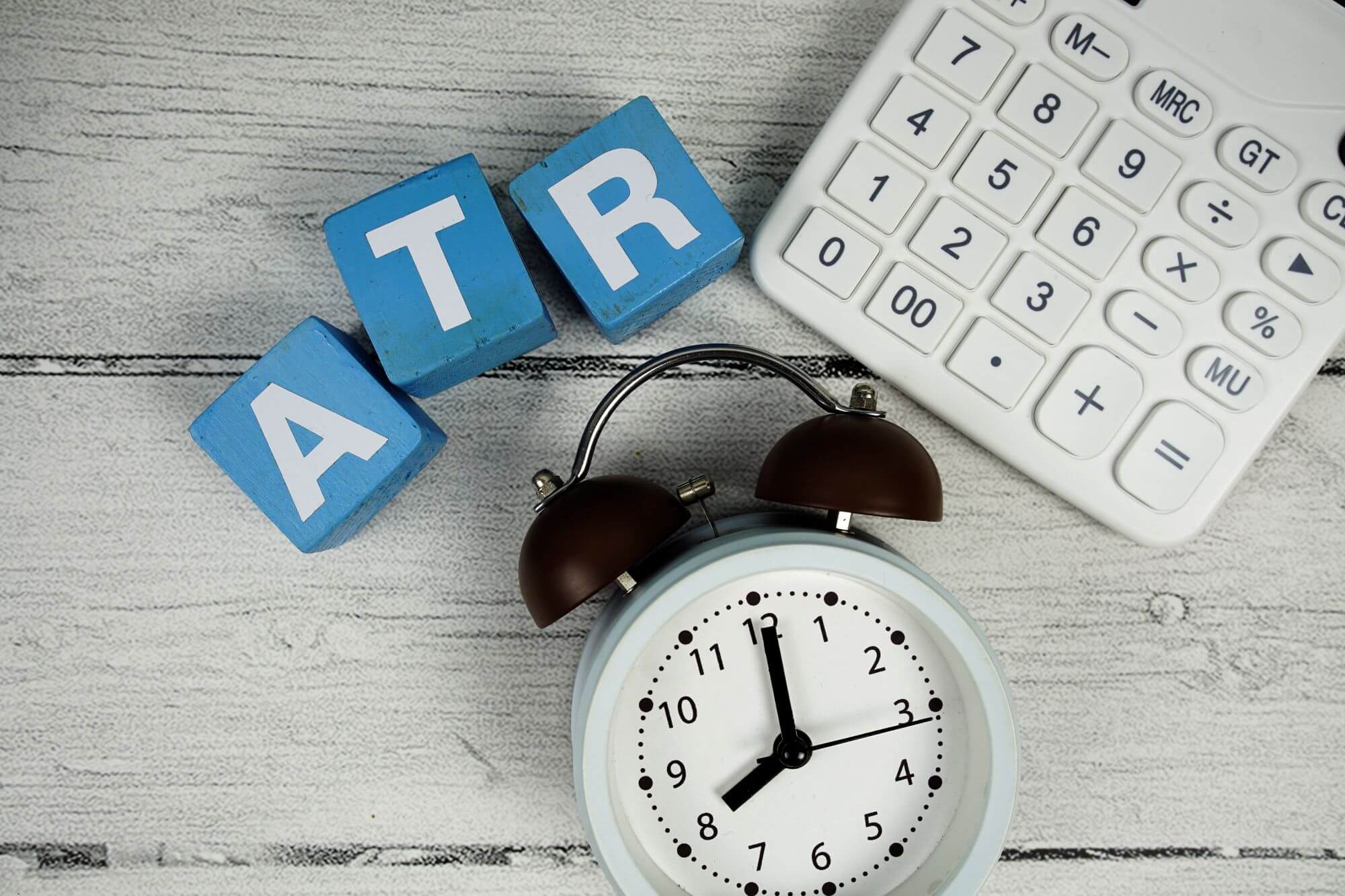 Imagen de una calculadora y un reloj al lado de unas fichas en las que se lee ATR