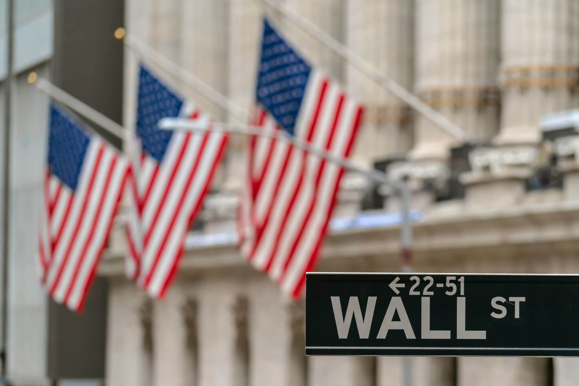Imagen de una calle en la que se ve un letrero que dice Wall Street