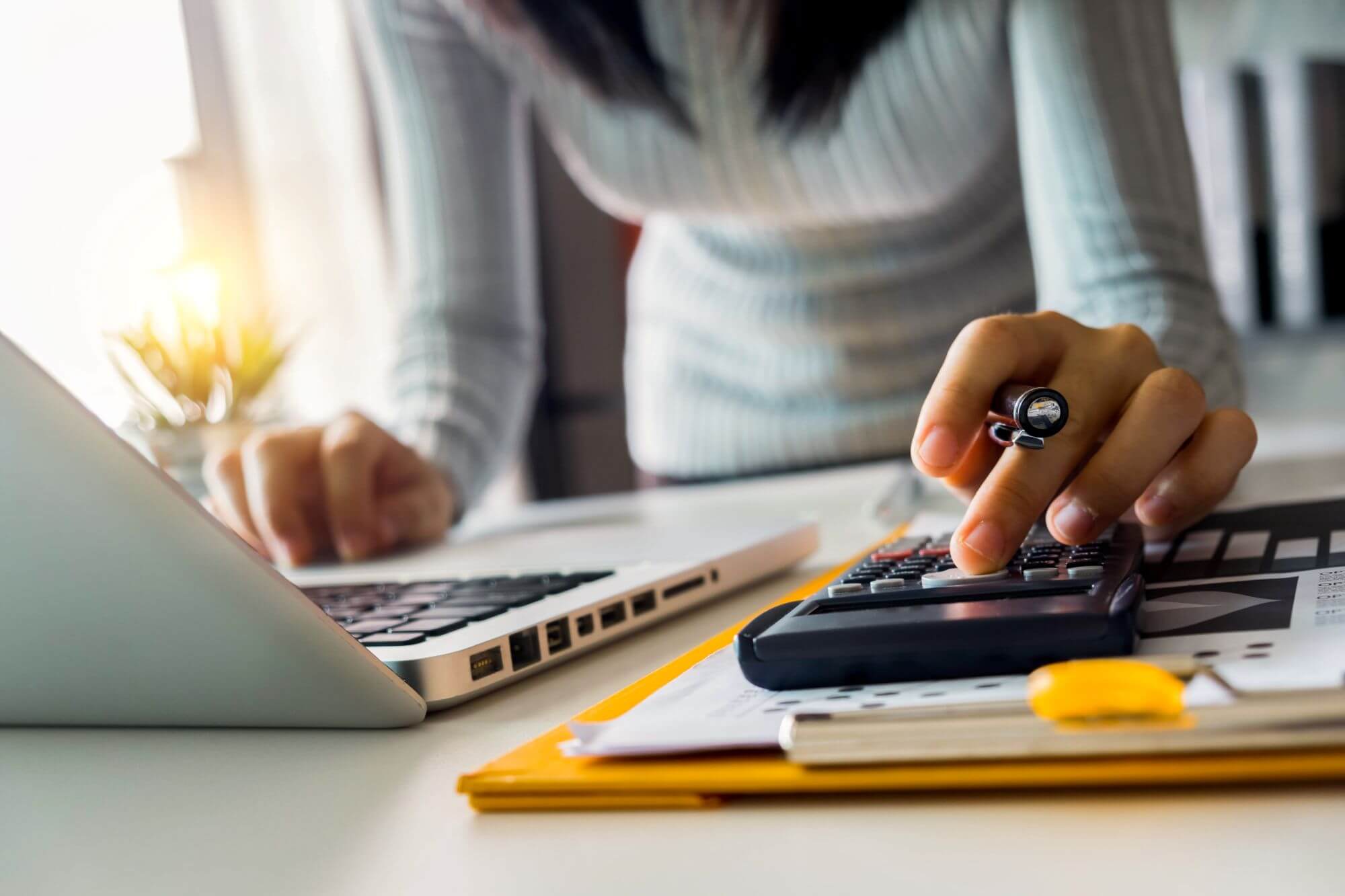 Imagen de una mujer con una calculadora en un artÃ­culo sobre quÃ© es la Tasa Tobin
