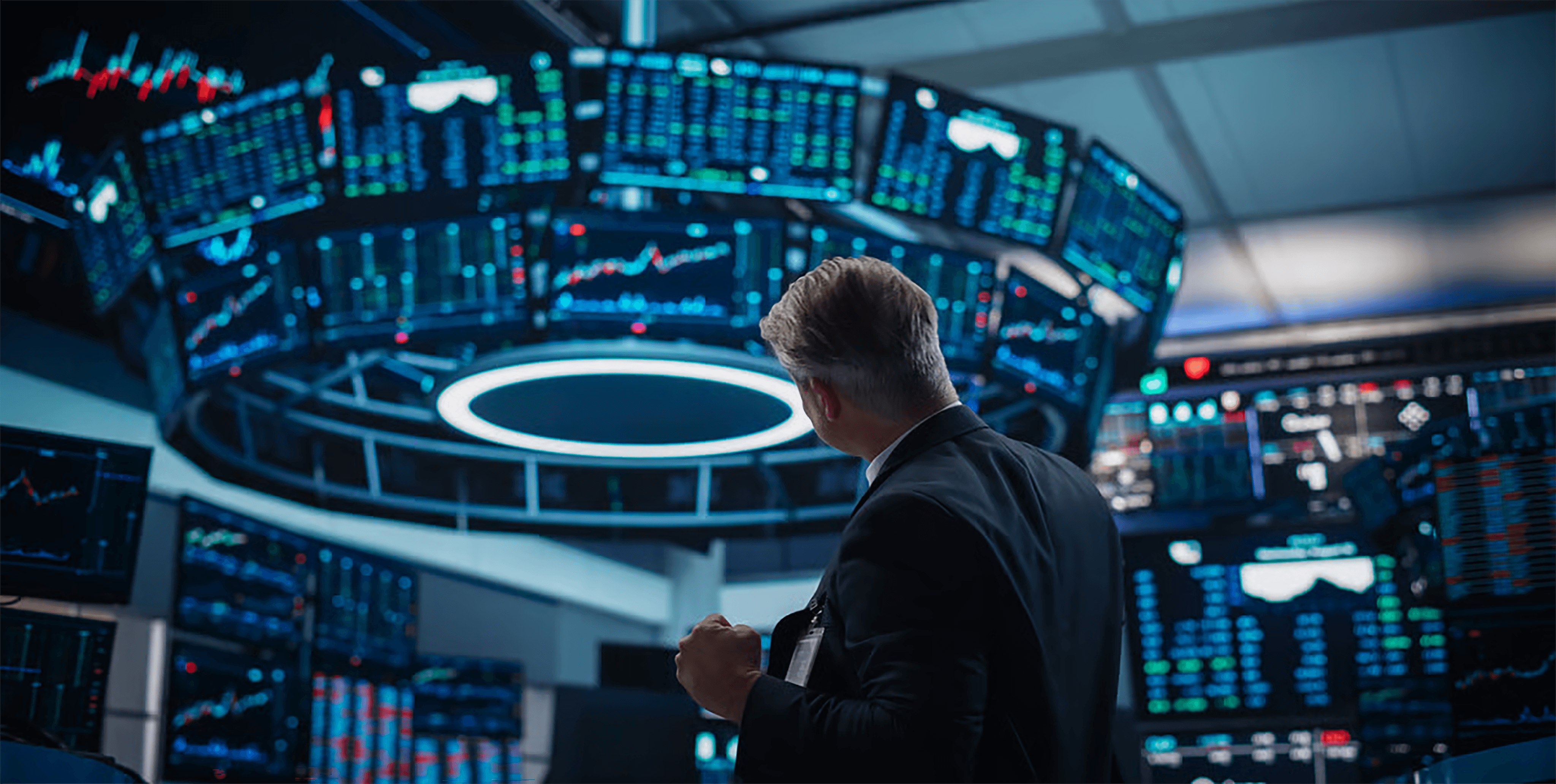 Investidor a observar dezenas de ecrÃ£s com grÃ¡ficos de investimento