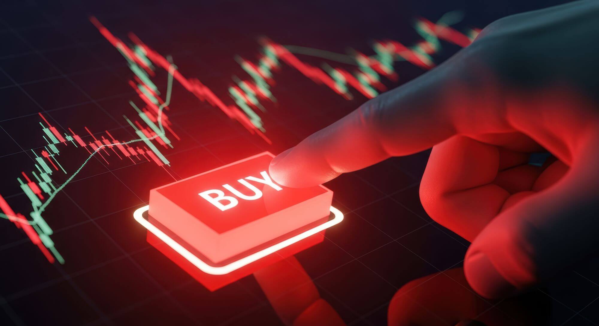 Imagen de un inversor pulsando un botÃ³n en el que se lee la palabra buy en un artÃ­culo sobre cÃ³mo comprar acciones