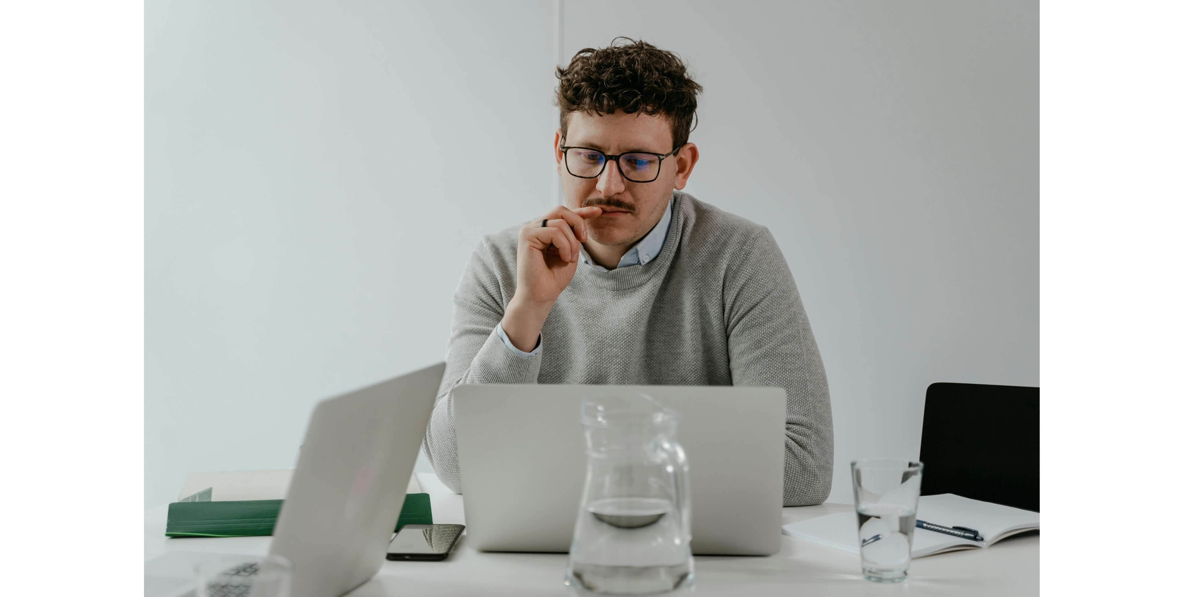 Homem com cara pensativa a olhar para ecrÃ£ de computador