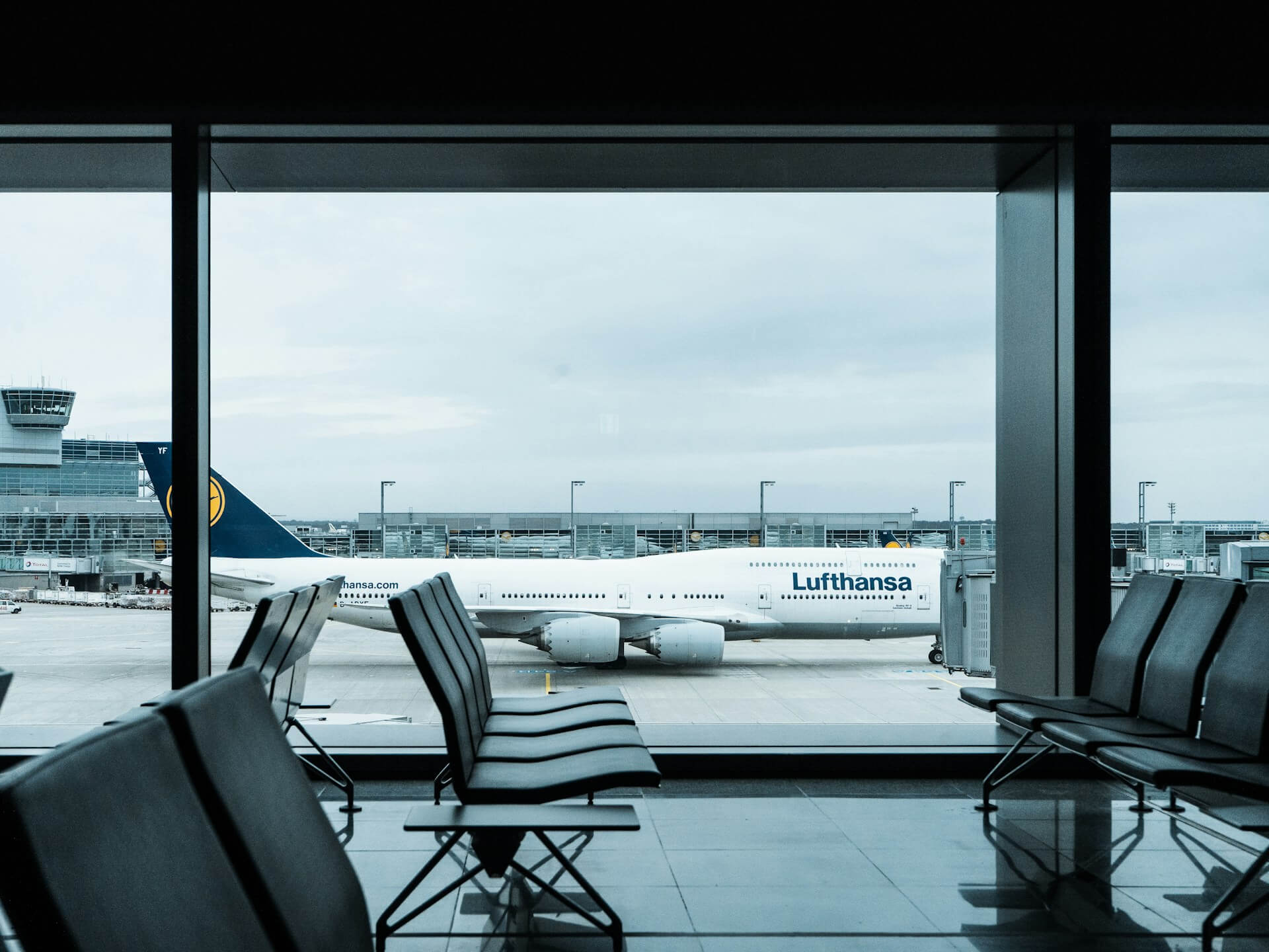 Sala de espera de aeroporto com vista para avião da Lufthansa