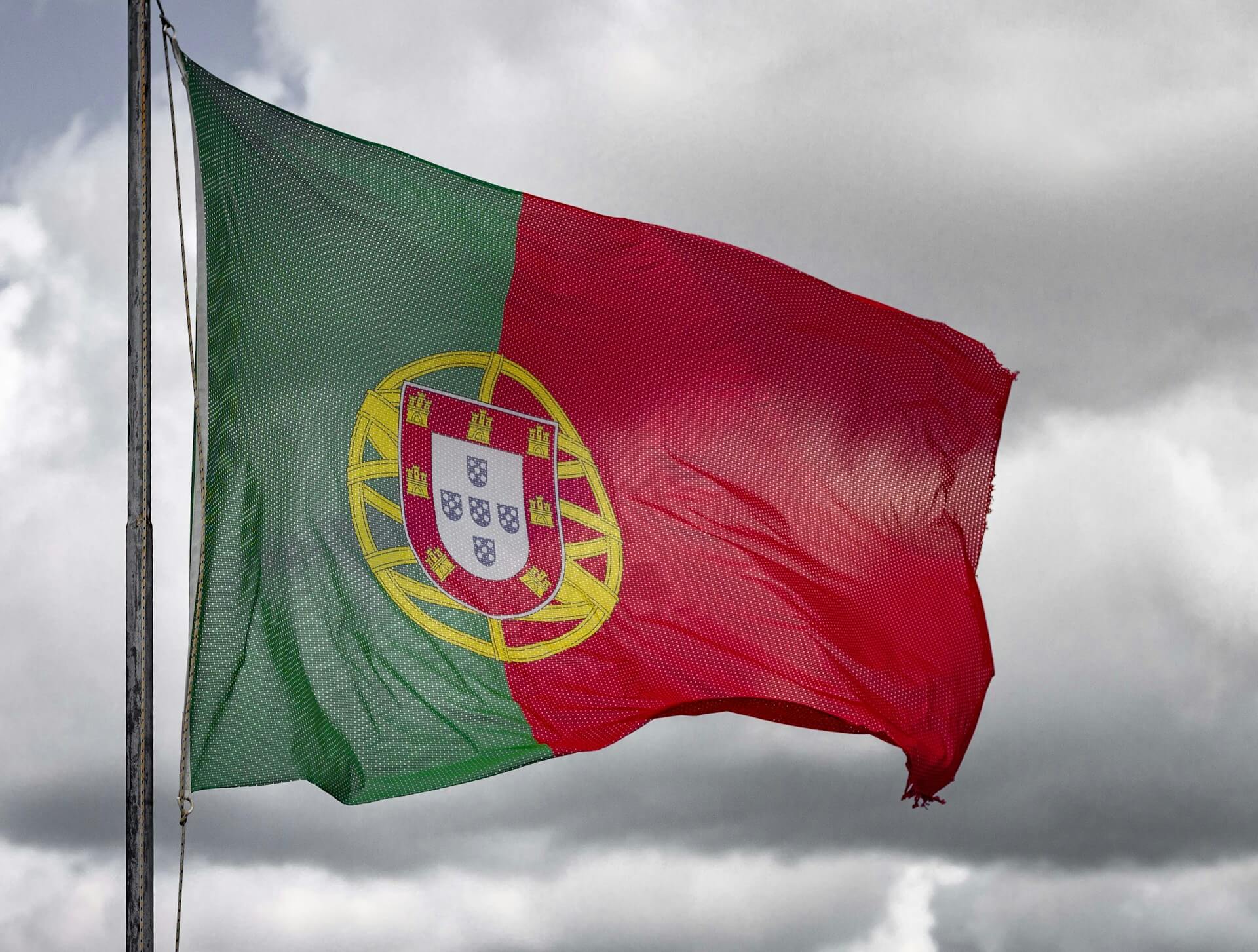 Bandeira de Portugal em fundo de céu nublado