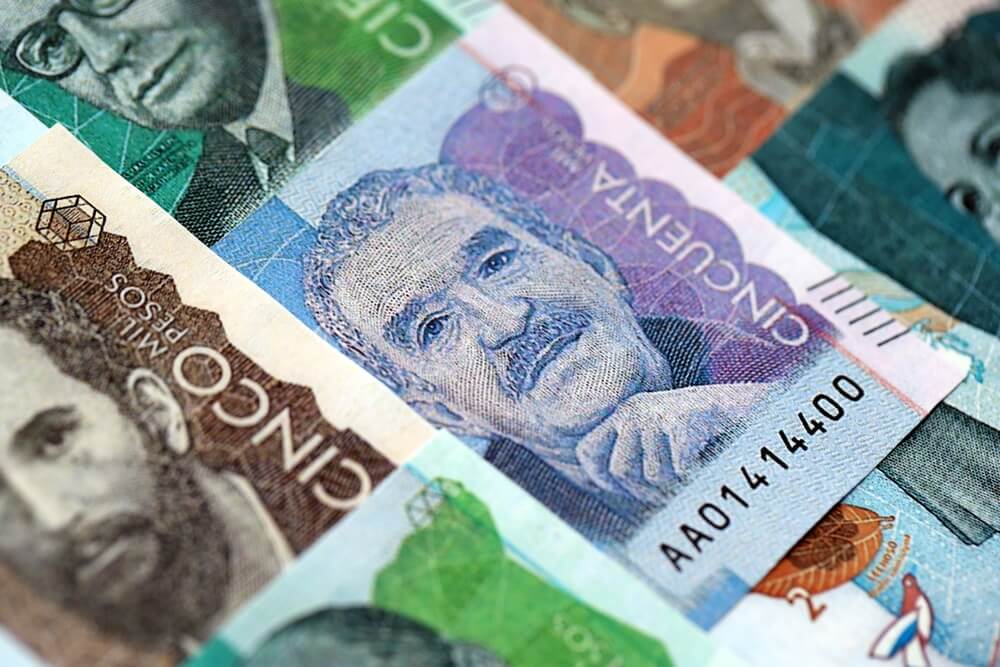 Los billetes en pesos colombianos se encuentran en una gran pila en la mesa de cerca