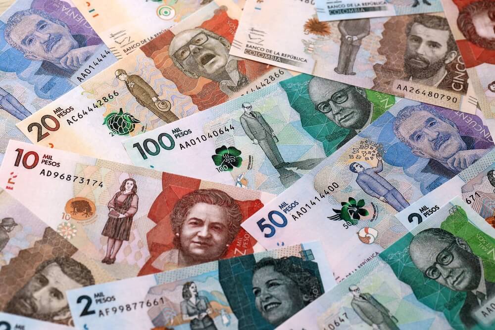 Los billetes en pesos colombianos se amontonan en la mesa. Cierre de los billetes de Colombia de la moneda COP.