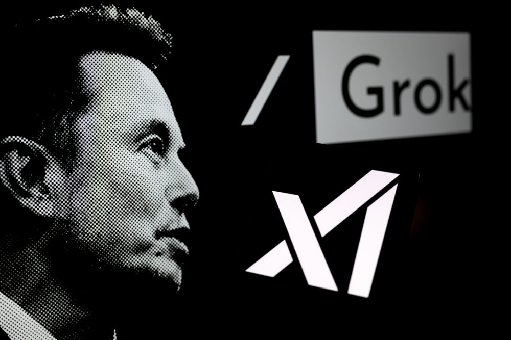 Logo Grok mostrado en un smartphone con Xai y Elon Musk visto en el fondo
