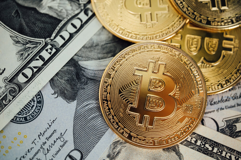 Monedas de bitcoin y billetes de dolares